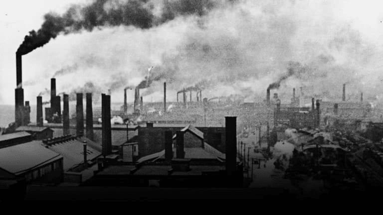 Historical photo of old factory with smoke coming up from chimneys